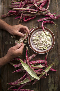 Close-up of person shelling beans