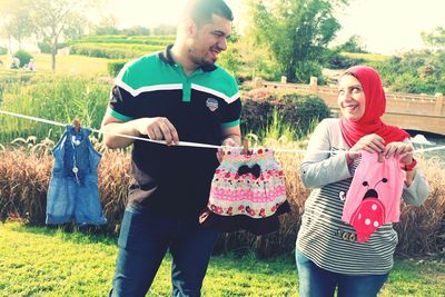 Smiling couple drying laundry on clothesline