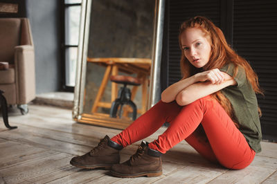 Young woman sitting on floor