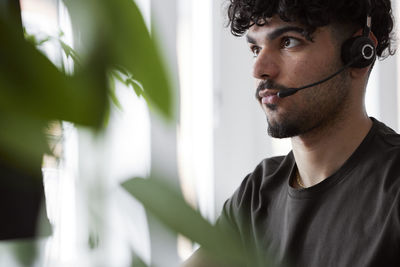 Young man wearing headset looking away