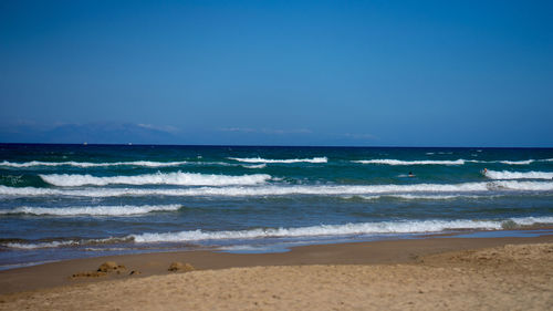 Scenic view of beach against blue sky