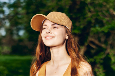 Portrait of young woman wearing hat standing outdoors