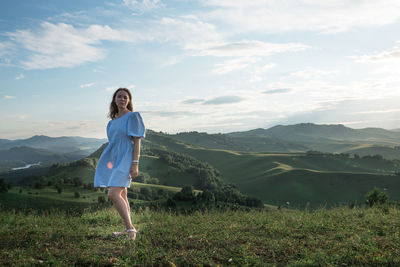 Full length of woman standing on field against sky