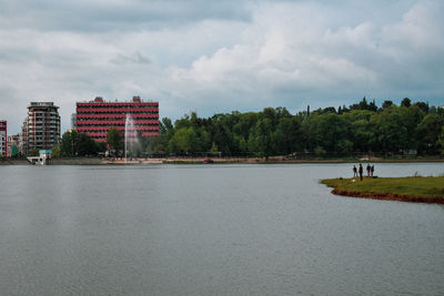 Scenic view of lake by buildings against sky