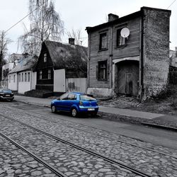 Cars parked on street by buildings against sky