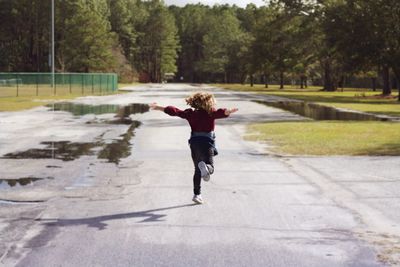 Rear view of boy running on tree