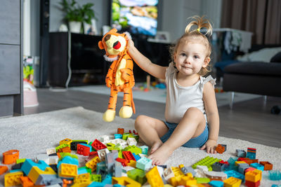 Cute girl playing with multi colored toy at home