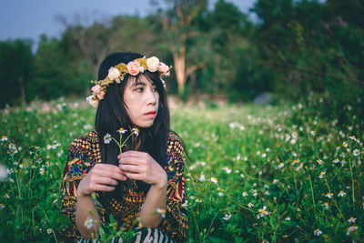 Portrait of beautiful young woman standing on field