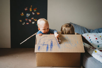 Kids playing and drawing in a box during lockdown