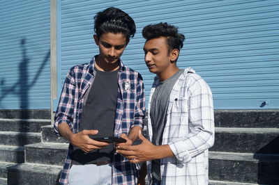 Young man standing against wall
