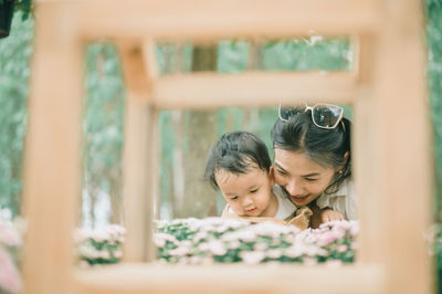 Mother and son standing by flowering plants