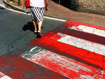 Low section of woman walking on road