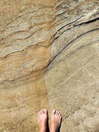 Low section of person standing on rock