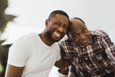 Portrait of happy male healthcare worker and senior man in retirement home
