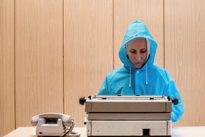 Woman using typewriter at desk in office