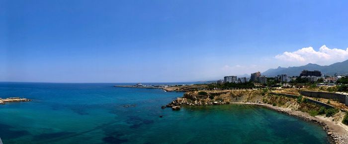 Panoramic view of sea and buildings against sky