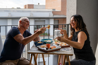 Side view of young woman having food at home