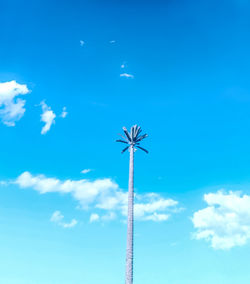 Low angle view of ferris wheel against blue sky