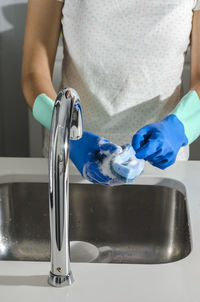 Midsection of woman washing glasses