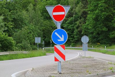 Road sign against trees