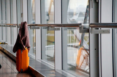 Jacket on suitcase by window at airport