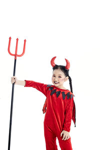 Portrait of happy girl holding red umbrella against white background