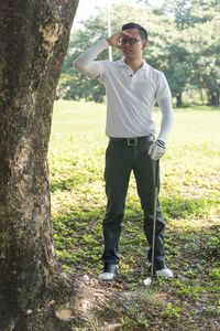 Rear view of man playing at golf course