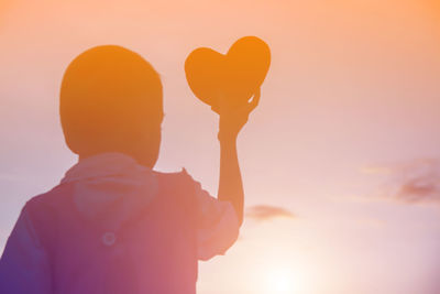 Portrait of silhouette boy against sky during sunset