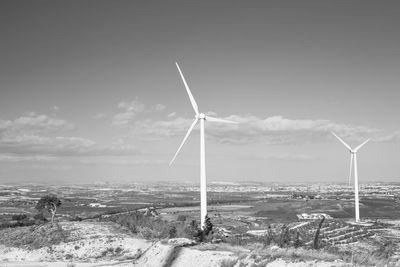 Windmill on field against sky