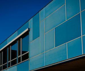 Low angle view of modern building against clear blue sky