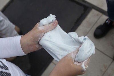 Cropped hand of person holding white clay