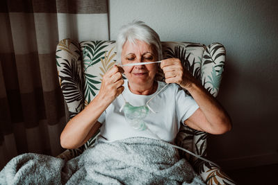 Portrait of man sitting on sofa at home