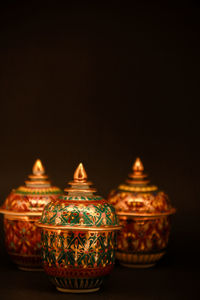 Close-up of illuminated candles on table against black background