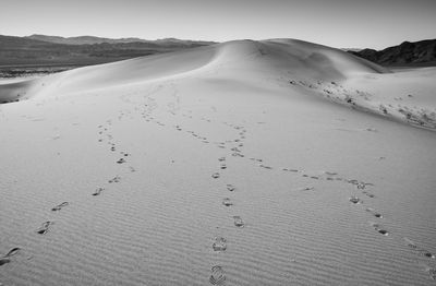 Scenic view of desert footsteps against sky