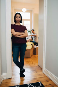 Full length portrait of woman standing at home
