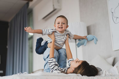 Portrait of boy playing with toy on bed at home