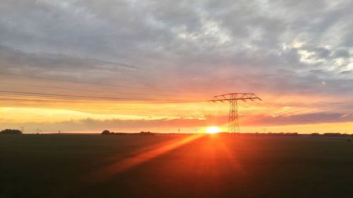 Scenic view of silhouette field against sky during sunset