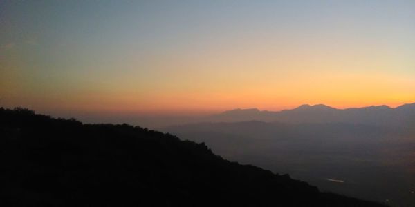 Scenic view of silhouette mountains against sky at sunset