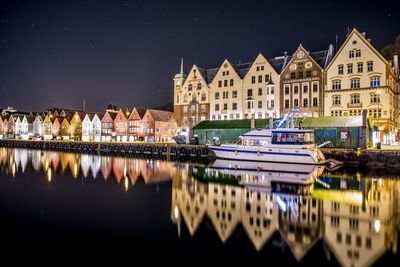 Illuminated buildings against sky at night