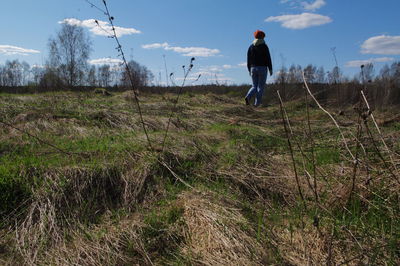 Rear view of man on field against sky