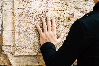 Midsection of woman touching wall