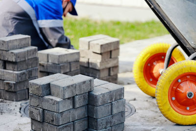 Bricklayer in work clothes sits on sidewalk and lays out paving slabs. sight of working man in open