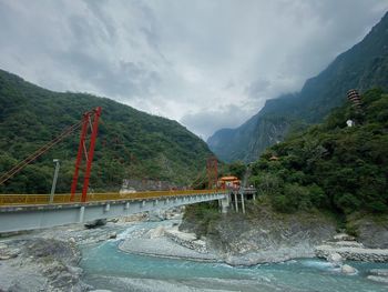 Scenic view of bridge over mountains against sky