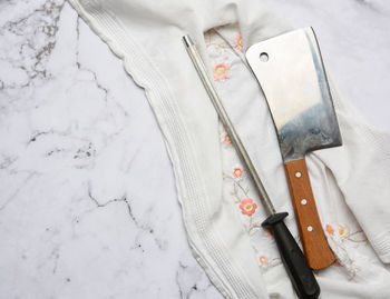 Knife and old iron sharpener with handle for kitchen knives on a white background, top view, co