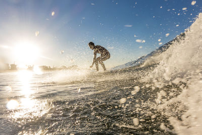 Man surfing on sea during sunset