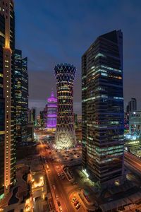 Illuminated modern buildings against sky in city at night