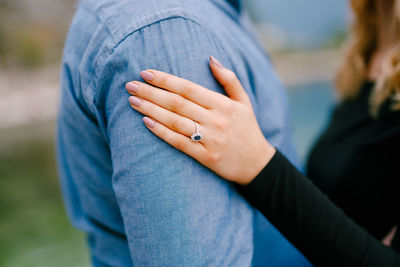 Midsection of couple holding hands