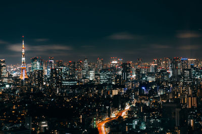 Illuminated cityscape against sky at night