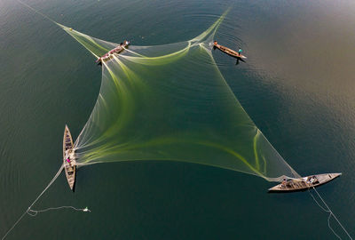 People spreading fishing net on sea