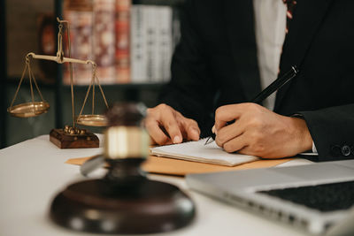 Midsection of lawyer working in office
